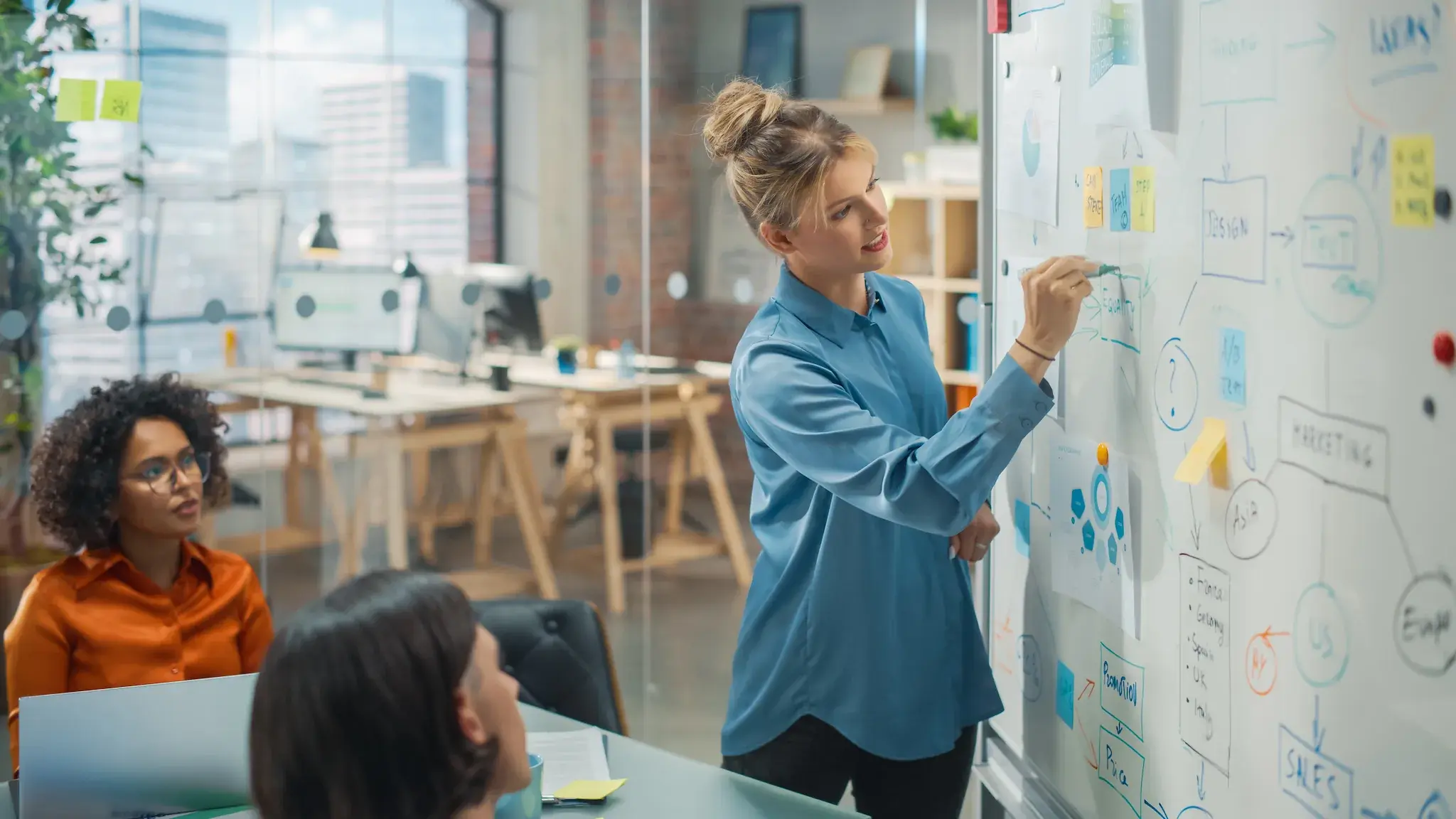 The company COO leading a meeting and brainstorming on a whiteboard